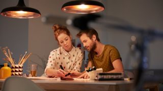 Dos personas creando un plan de iluminación en un escritorio bien iluminado