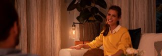 Een man die het aantal watt controleert op de productverpakking van een lamp voor huishoudelijk gebruik