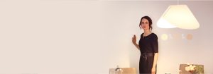 "Woman adjusting bright LED recessed lighting via sleek wall-mounted dimmer, enhancing modern living room's ambiance and energy efficiency."