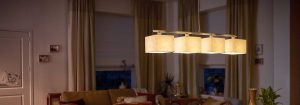 Die moderne LED-Pendelleuchte mit mehreren Stoffschirmen beleuchtet ein gemütliches Wohnzimmer und präsentiert energieeffiziente und stilvolle Beleuchtungslösungen für ein gemütliches Ambiente am Abend.