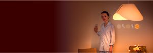 "Une femme ajuste l'éclairage LED avec un interrupteur mural, mettant en valeur l'ambiance chaleureuse d'une grande lampe LED et des options de luminosité personnalisables dans une chambre confortable."
