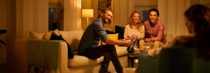 "Warm LED lighting creates cosy ambiance for friends socialising in living room, highlighting energy-efficient illumination for evening gatherings."