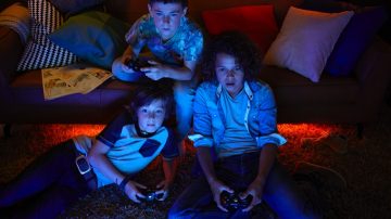 3 boys playing video games with ambient lighting