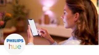 Woman controlling the lights in her living room with her smartphone
