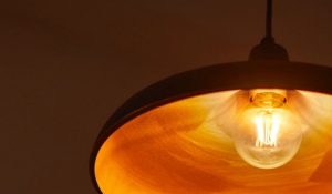 "Vintage-style LED filament bulb in pendant lamp, emitting warm golden glow, showcasing energy-efficient nostalgic lighting for cosy home ambiance."
