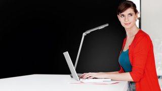 "Child studying at desk with adjustable LED task lamp, providing optimal illumination for homework in colorful home learning space."