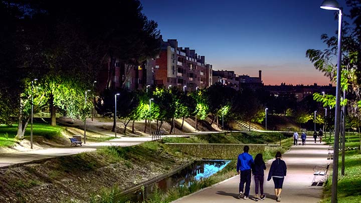 Friends walking in well lit park at night