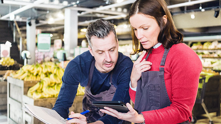 Store owners discussing over tablet