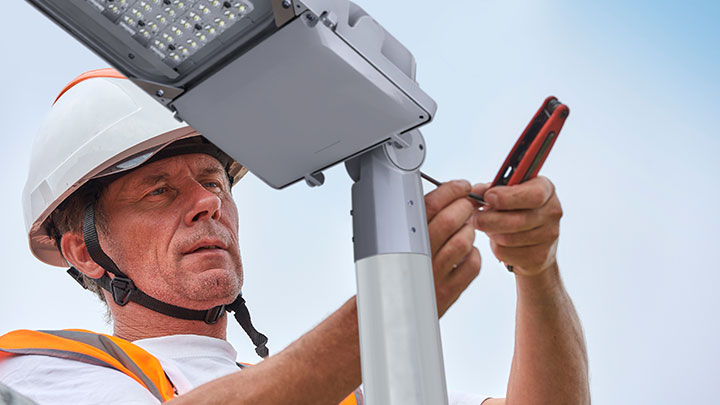 Engineer installing street light in park