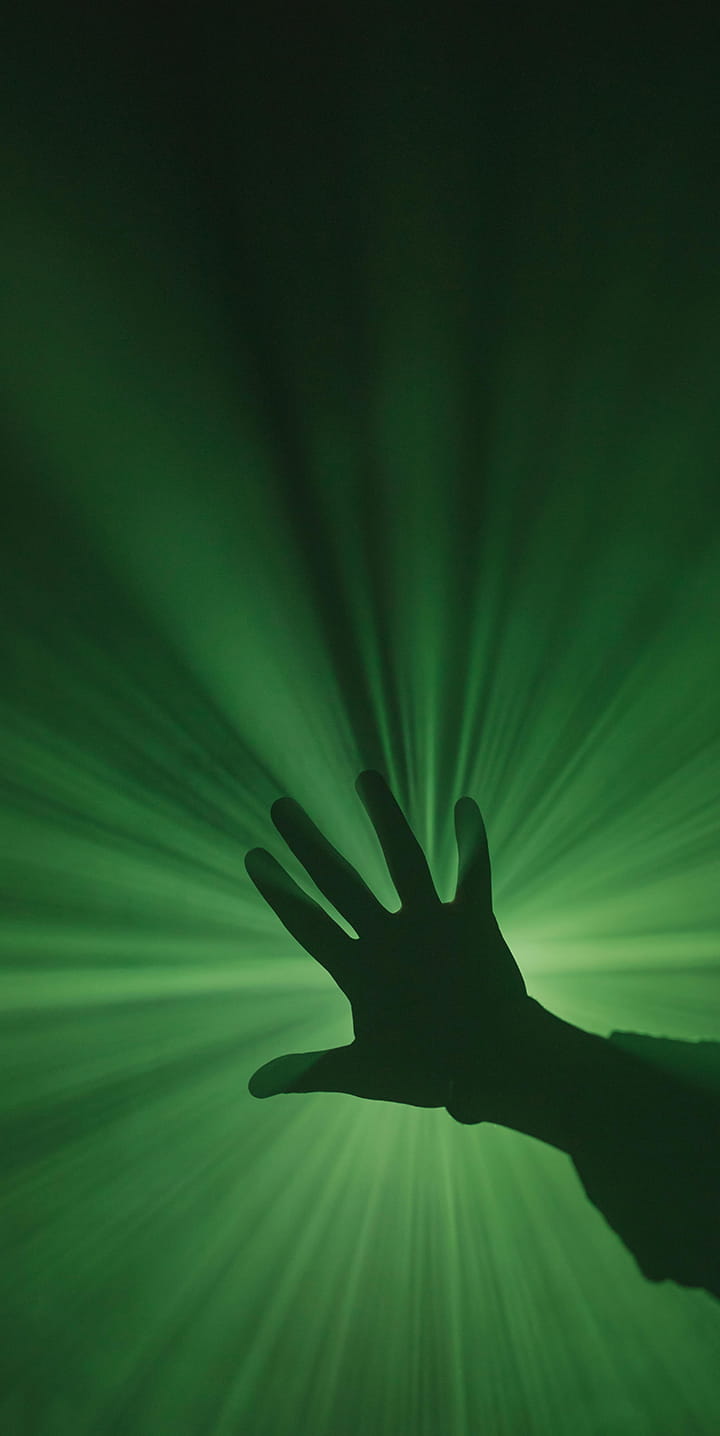 Hand with green lighting in background