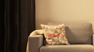 Cosy living room with modern LED table lamp, illuminating grey loveseat and creating warm ambiance for home relaxation.