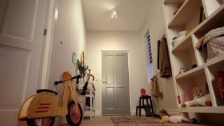 Entrée lumineuse avec éclairage encastré DEL illuminant les étagères, les jouets et un vélo d'équilibre pour enfants.