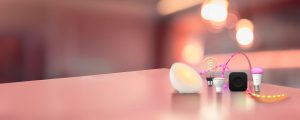 A Philips Hue Signe gradient table lamp washes a wall in purple and pink tones of smart light.