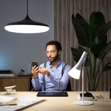 Mann arbeitet von zu Hause aus mit smarten Philips Hue Lampen, um sich besser auf seine Aufgabe konzentrieren zu können
