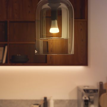 Eine smarte Hue Lampe leuchtet in einem einstellbaren warmen Weißlicht.