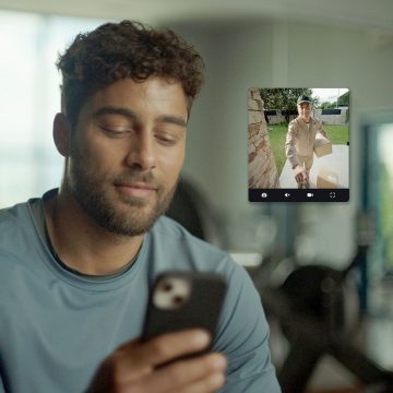 Un homme voit un livreur devant sa porte d’entrée sur son téléphone intelligent avec l’application Hue.