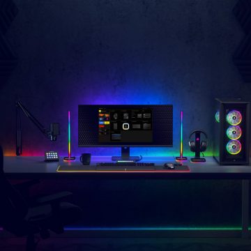 Un bureau de jeu avec des périphériques Corsair et des lampes Philips Hue colorées.
