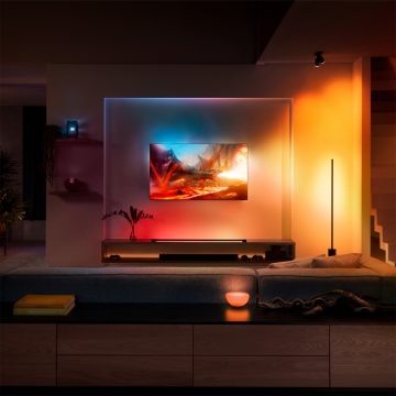 Téléviseur accroché au mur dans le salon entouré d'un jeu de lumières colorées