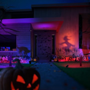Une jardin décoré pour Halloween avec des lampes extérieures Philip Hue compatibles avec la couleur qui créent une ambiance effrayante avec des citrouilles et des ombres spectrales.