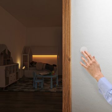 De hand van een vrouw die op de slimme Hue-knop (nieuwste model) drukt om de verlichting in een kinderkamer te bedienen