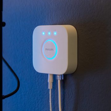 Hue Bridge-enheten hänger på en blåfärgad vägg.
