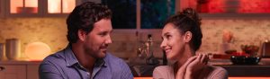 Couple looking at each other with smart table lamp in background 