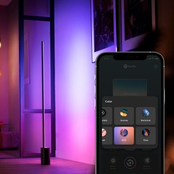 Smarte Stehlampe mit mobilem Gerät, das die Galerie mit Hue Szenen in der Hue App anzeigt