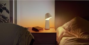 Bett, Gemälde, Pflanze und Vorhänge in lilafarbenem smarten Licht in einem Schlafzimmer