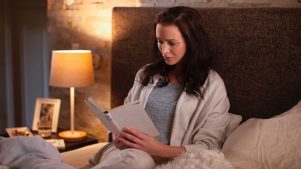 Woman sitting in a bedroom reading