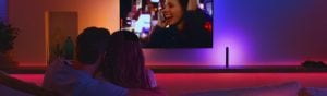 Couple watching TV with Philips Hue Play light bar near television