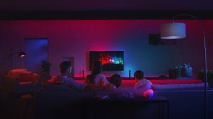 Family watching TV backlit with colorful Philips Hue smart lighting