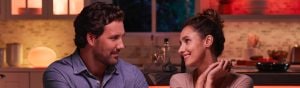 Couple looking at each other with smart table lamp in background 
