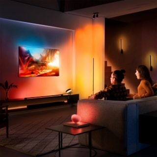 Couple sitting on couch watching TV with red, orange, yellow lights