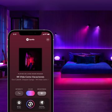 Bedroom with smart table lamps and smart spotlights with a mobile device showing Sync tab in Hue app