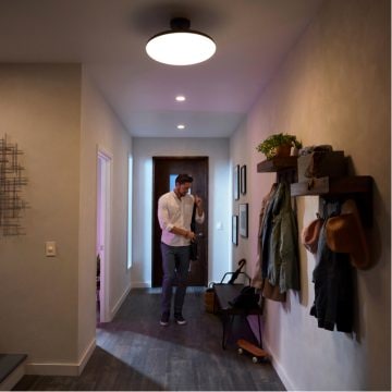 Man putting on coat in front hallway of home