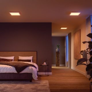 Ceiling-mounted square smart lights illuminate a bedroom and hallway, casting soft light on the bed and surrounding furniture.