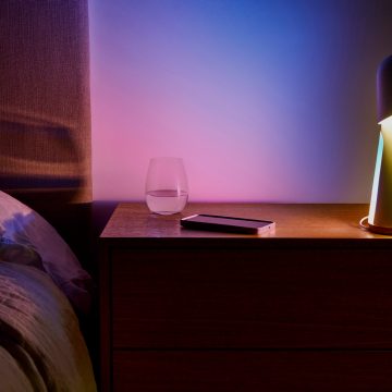 Una pared de dormitorio bañada con luz inteligente en una sutil mezcla de tonos azul y rosa.