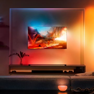Téléviseur Samsung accroché au mur dans le salon entouré de lumières colorées 