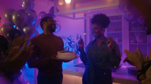 Un groupe de personnes célébrant joyeusement lors d'une fête animée sous un éclairage d'ambiance vibrant qui renforce l'atmosphère festive et énergique.