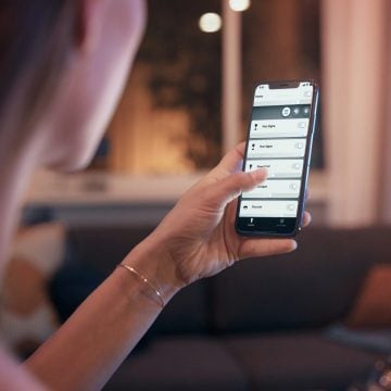 Femme qui tient un téléphone montrant l'application de lumière connectée