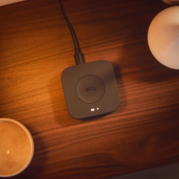 Un hub luminoso smart Hue Bridge Pro nero posizionato su un tavolo