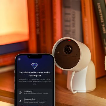 Een witte Hue Secure camera en de Hue app tonen geavanceerde beveiligingsfuncties, die beschikbaar zijn in het Plus-abonnement.