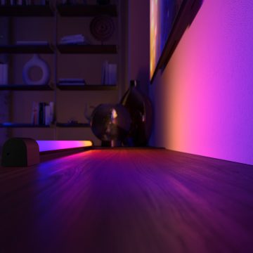 Een Hue gradient light tube die een mix van blauwe, roze, paarse en gele tinten slim licht over een muur laat schijnen.