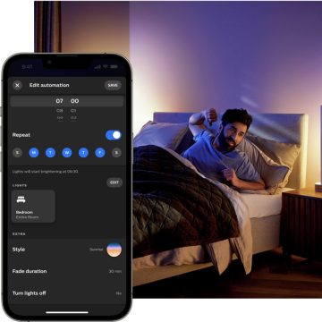 Mulher a dormir na cama com um candeeiro de cabeceira suavemente iluminado por luz inteligente vermelha e laranja