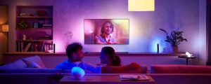Two people on couch watching TV with surround lighting